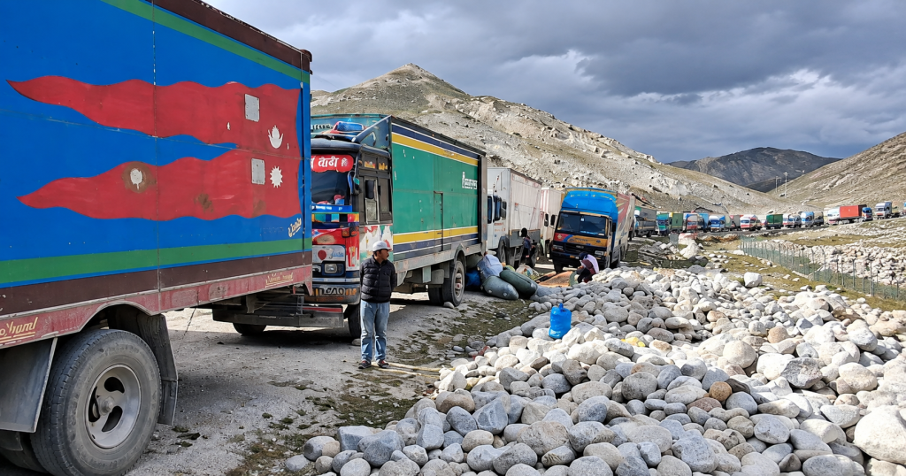कोरला नाकाको उच्च हिमाली क्षेत्रमा मालवाहक ट्रकको लामो लाइन र व्यापारिक चहलपहल।